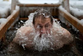Les Russes sautent dans l`eau glacée sous la neige pour se purifier